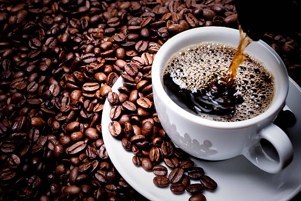 Café preto na xícara com grãos de café em volta