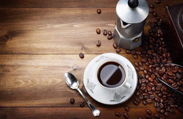 grãos de café proximo à xícara de café
