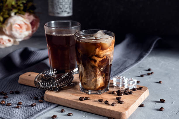 Café gelado em um copo alto com creme em fundo escuro