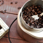 Moedor de café elétrico com grãos de café torrados