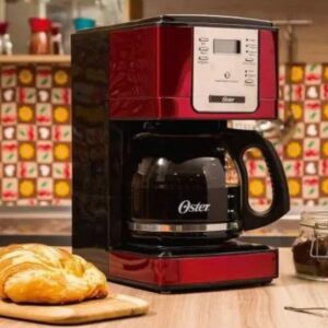  Cafeteira Oster Flavor Programável em cima da mesa da cozinha com pão ao lado