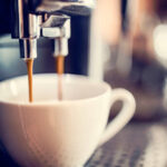 Máquina de café expresso fazendo uma xícara de café fresco